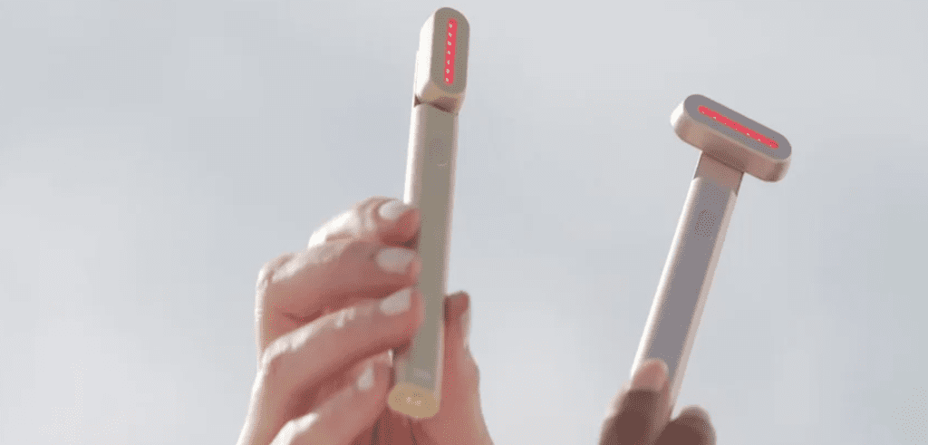 holding the Solawave 4-in-1 Radiant Renewal Skincare Wand with 14 LEDs turned on