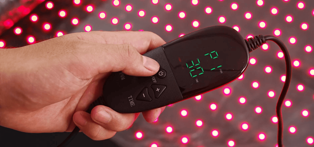 Hand holding the MEGELIN Red Light Therapy Bag controller with digital display and adjustment buttons